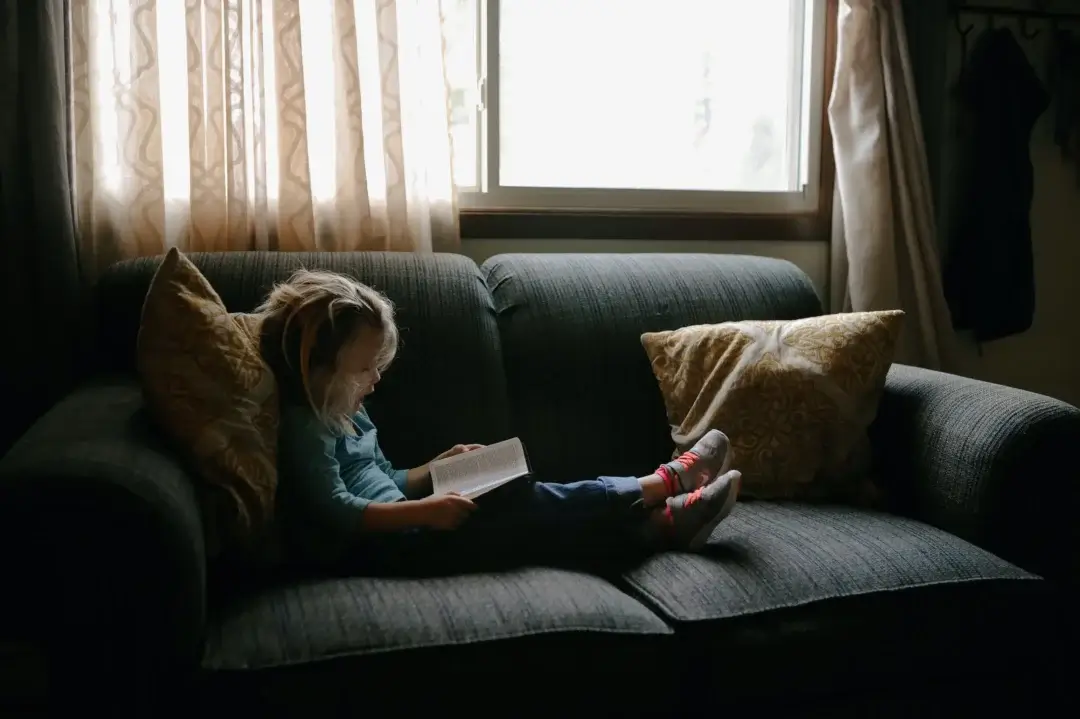 A little girl lost in a book